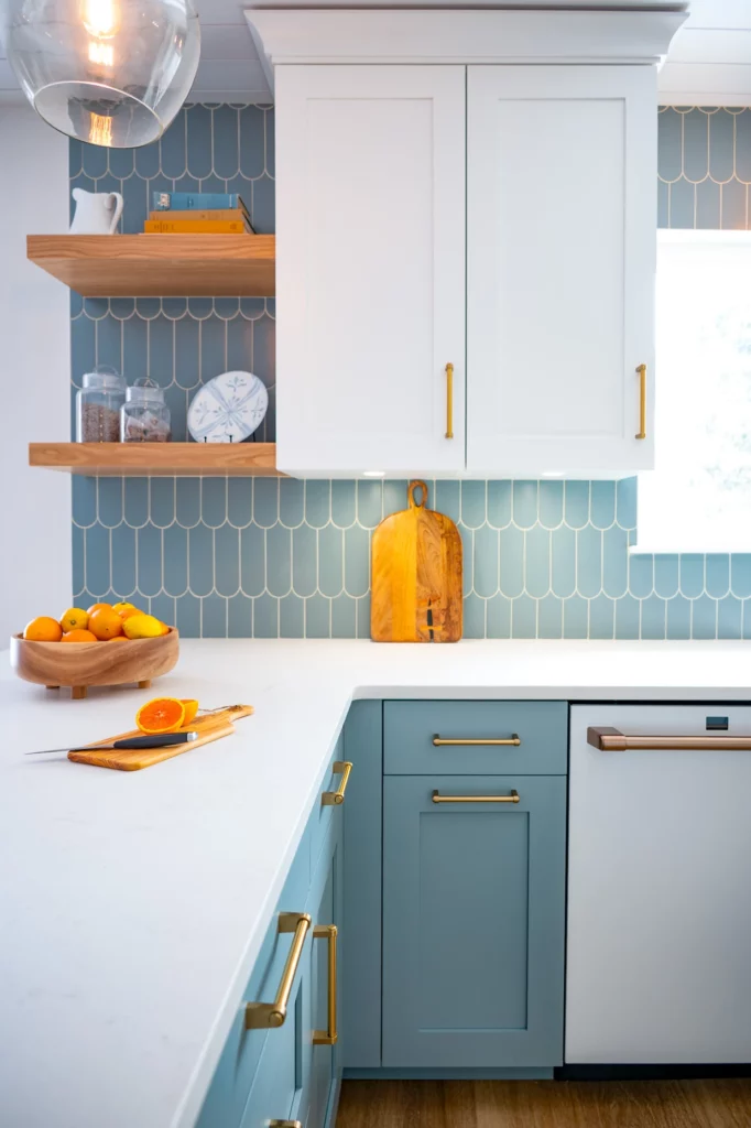 Sleek kitchen cabinetry in white with blue cabinet and tile accents