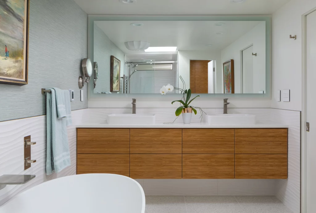 Double sinks in bathroom with large mirror and tub